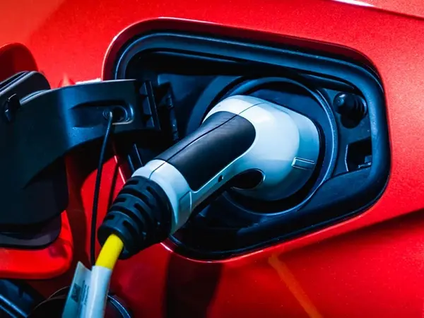 Ein Elektroauto wird mit Ladekabel an einer Ladesäule aufgeladen, Nahaufnahme.